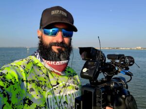Fishing TV Producer out on the water with his camera documenting fishing content