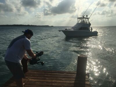a cameraman shooting video of a boat on the water on a cloudy day. The content will be used for fishing guide advertising